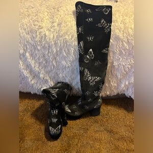 Black knee-high boots with sparkly butterflies